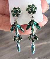 Close-up front view of vintage Sherman emerald green drop earrings showing detailed floral cluster and marquise crystal design.