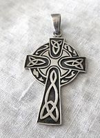 Front view of vintage sterling silver Celtic cross pendant showing intricate Celtic knot designs and oxidized background.