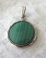 Front view of circular vintage sterling silver pendant with green malachite stone showing natural pattern and scalloped silver border.