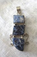 Front view of sodalite pendant showing three irregular sodalite stones in silver bezels with twisted connecting design.