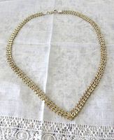 Full length view of the two tone silver and gold fancy link necklace laid flat