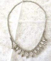 Full view of vintage Jay Flex sterling silver rhinestone necklace laid flat on white fabric, showing overall length and design.