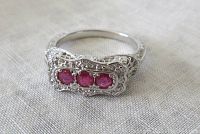 Front view of ring showing three round rubies in filigree setting