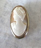 Front view of oval cameo brooch pendant showing detailed profile of woman facing left