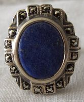 Close-up photo of the ring's front showing oval lapis lazuli stone surrounded by marcasite gems in Art Deco style.
