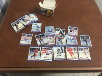 Photo showing the 40 hockey cards spread and stacked with the box on table.
