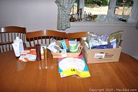 Photo showing multiple containers of creams, lotions, and samples arranged on a dining room table.