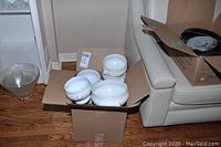 Box containing two sets of white soup tureens and matching bowls, stacked and showing signs of light wear