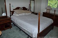 Full view of queen bed frame, mattress, bedding and two nightstands