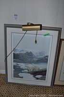 Full view of framed and matted print leaning against wall with pickup tag