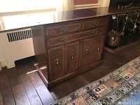 Front view with top closed showing two small top drawers, one lower drawer and four cabinet doors