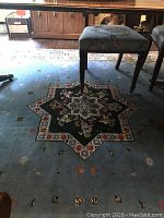 Central section of rug under dining table showing star-shaped medallion and scattered floral motifs