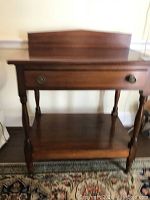 Front view of the solid wood side table showing drawer with two round pull handles and bottom shelf.