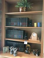 Three-shelf unit with all 60 Great Books volumes, assorted bookends, two small colored mugs and wood clock