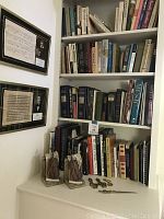 Bookshelf view showing assortments of music books, violin bookends and paperweights