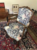 Front right three-quarter view showing overall design, carved frame and upholstery pattern