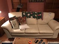 Front view of white leather sofa with cushions