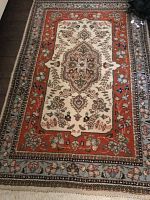 Full view of the Persian area rug showing central medallion and borders.