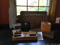 Photo of entire wood and stone lot on a table with window in background. Shows multiple wooden items, a black object, and boxed resin kangaroo figurine.