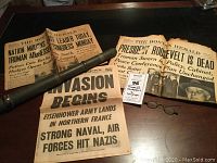 Photo showing multiple newspapers with WWII and Roosevelt death headlines, Bell & Howell telescope and spectacles