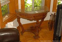 Full view of demilune console table against window with plexiglass top protector