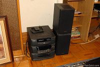 RCA RS 1285 audio system stacked with two Panasonic speakers beside it in room corner.