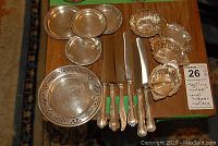 Overview of six dinner knives, round coasters, pierced dish and small serving dishes