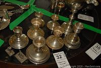 Top-down view of six small sterling silver candlestick holders with varying rim designs