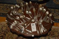 Assorted spoons, forks and tea bag strainers on wooden table