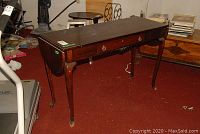 Full view of the wooden console table showing elegant curved legs and two drop leaves down.