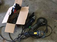 Four electric angle grinders on floor including JobMate in box with manual, MasterCraft, Bosch mini grinder, and another grinder.