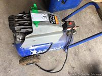 Side view of blue Michelin electric air compressor on wheels, showing motor, protective cover, power switch and black cable.