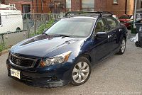 Front driver’s side three-quarter view showing dark blue finish, front bumper scuff and roof rack