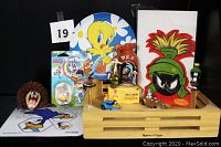 Full lot of Looney Tunes collectibles displayed on black background, including wooden box and various figurines.
