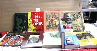 12 assorted books laid out on a table showing various titles and genres.