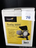 Original packaging box for Impact Qualite 300W Continuous Tungsten Light showing product features and branding.