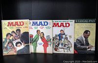 Photo shows all four items upright against black background: three MAD Magazine issues (#184, #188, #189) and OJ's Legal Pad book.