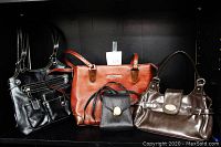 Four women's designer purses: black multi-compartment shoulder bag, brown Rina Rich leather tote, small black Leatherrock Nina Arjani purse, and brown Rosetti New York handbag.