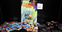 Front view of sealed Trunks action figure in blister packaging with scattered trading cards around it showing characters and scenes from Dragon Ball Z.