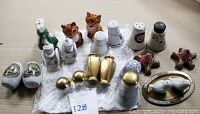 Photo showing 23 vintage salt and pepper shakers of various types, including animal figures, commemorative pieces, and metal and ceramic materials.