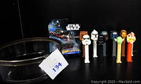 Photo showing 10 Star Wars PEZ dispensers including Stormtrooper, Darth Vader, Boba Fett, Yoda, C-3PO, and others, a new old stock Hot Wheels Star Wars "The Fighter" carship in original packaging, and a vintage glass bowl with silver plated rim.