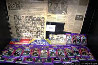 Full spread showing 36 packs of The Beatles Collection trading cards with vintage newspaper clippings and memorabilia behind