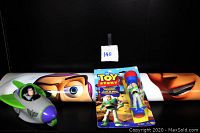 Photo of Buzz Lightyear spaceship toy on the left and new in package Buzz Lightyear flashlight on the right with Toy Story themed backdrop