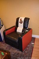 Full front-angle view of black, red and white leatherette recliner chair with cup holders