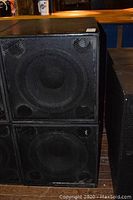 Front view of two Martin subwoofers stacked showing metal grille and woofer.