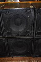 Front view showing four stacked speaker enclosures with metal grilles