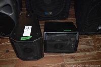 Two Community speakers on wooden floor with surrounding equipment