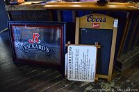 Wood-framed Rickard's promotional mirror leaning against counter