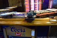 Coors Banquet sign on bar surface showing wiring and plug
