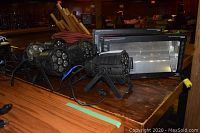 Overview of two rectangular stage lights with mounting brackets and rotating colored dance lights on wooden surface